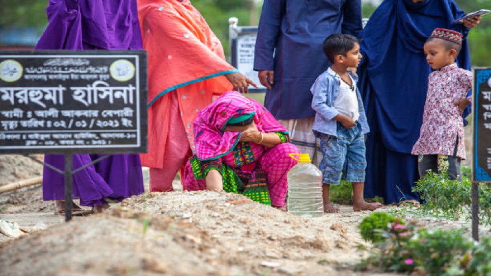 মৃত ব্যক্তির কবরের সামনে কাঁদছেন স্বজন-ছবি সংগৃহীত 