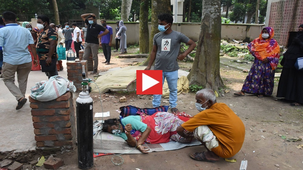 যশোর জেনারেল হাসপাতালের করোনা ওয়ার্ডে করোনা উপসর্গ নিয়ে সোমবার রাতে ভর্তির পর বেড না পেয়ে হাসপাতালের বাইরে গাছতলায় রাখা হয় রিনা খাতুন নামের এক রোগীকে-ছবি: সময় ট্রিবিউন 