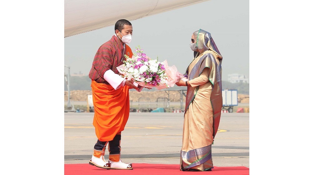 ভুটানের প্রধানমন্ত্রী লোটে শেরিংকে ফুল দিয়ে অভ্যর্থনা জানাচ্ছেন প্রধানমন্ত্রী শেখ হাসিনা।