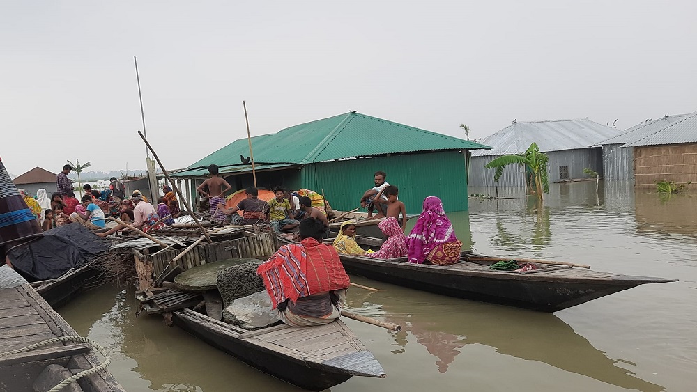 বন্যায় নৌকায় অবস্থান নিয়ে বানভাসি মানুষ- ছবি: সময় ট্রিবিউন